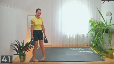 Walking lunge demonstration with two kettlebells